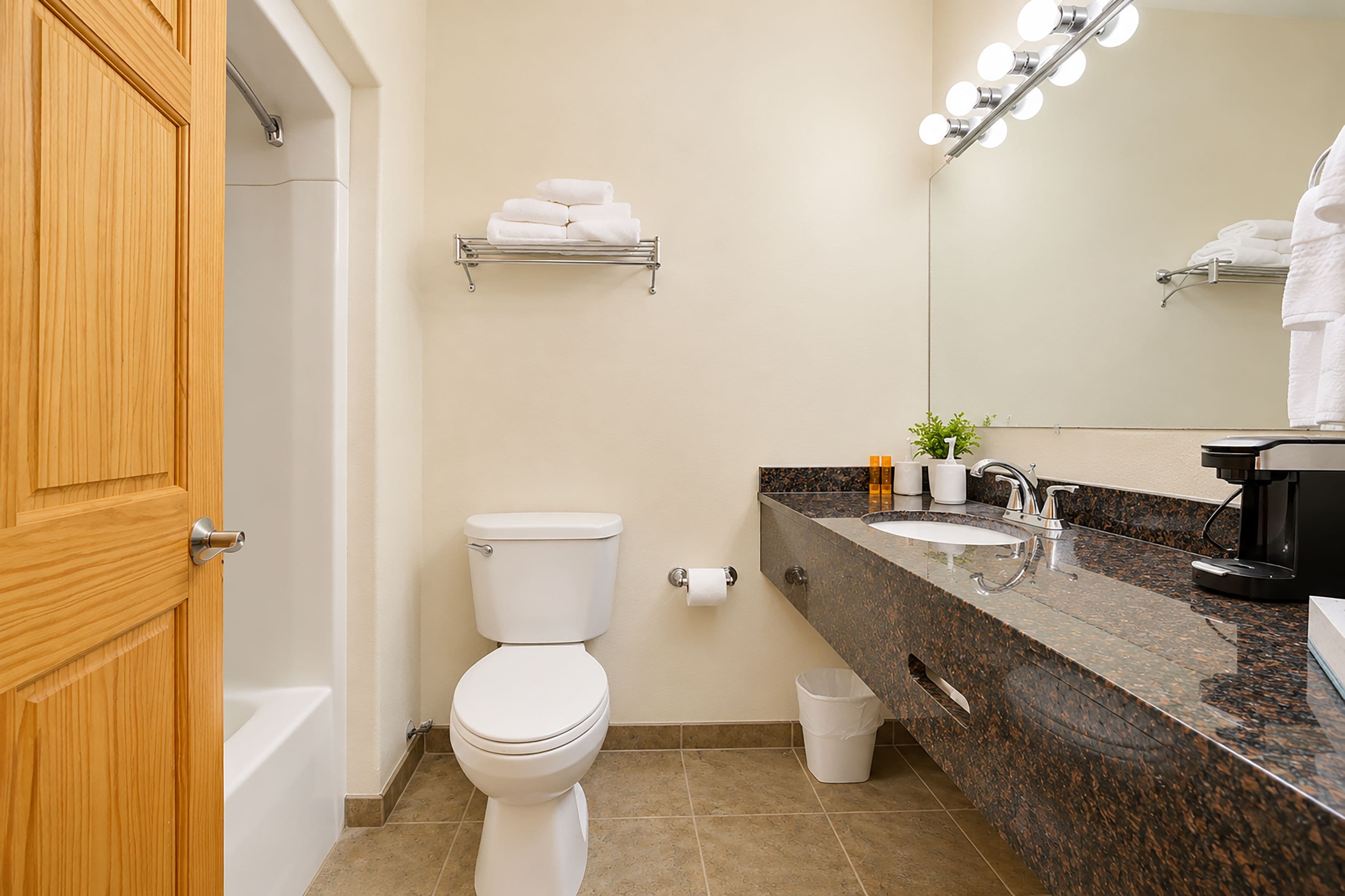 Une salle de bain avec des toilettes, un lavabo et un miroir.