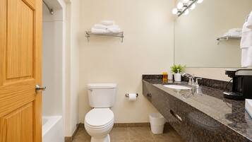 Une salle de bain avec des toilettes, un lavabo et un miroir.