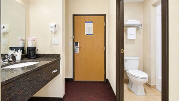 Ein Hotelbad mit Waschbecken, Spiegel, Handtuchhalter und Toilette.
