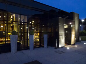 Un edificio moderno con amplios ventanales y una entrada bien iluminada.
