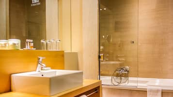 Een moderne badkamer met een grote spiegel, een wastafel en een douche met glazen wanden.