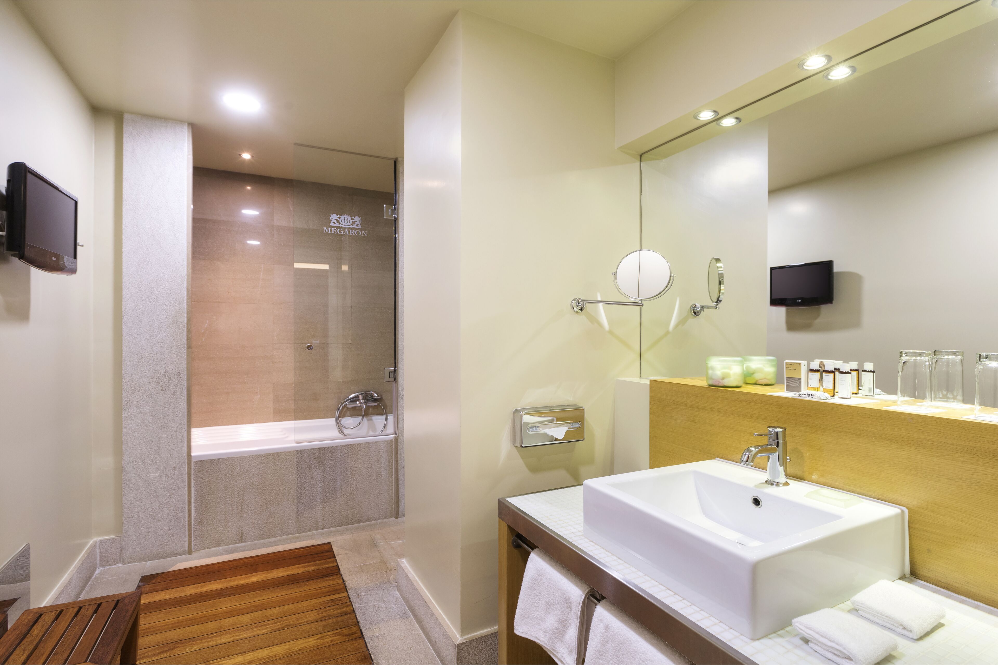 Une salle de bain moderne avec un grand lavabo, un miroir et une douche à parois de verre.