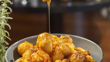 A bowl of food with honey being drizzled over it.
