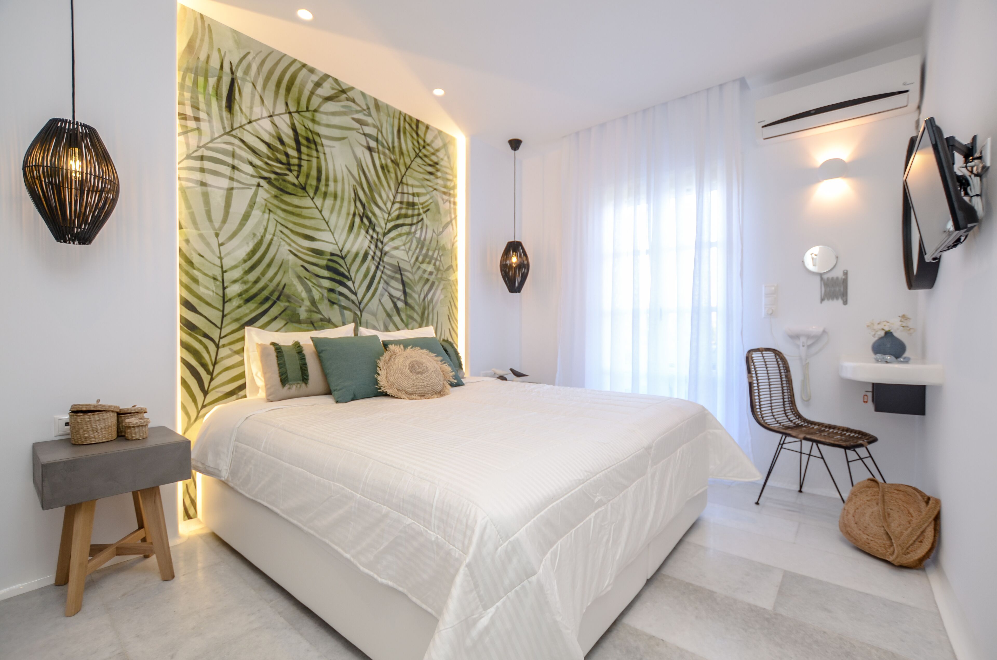 Un dormitorio moderno con una cama grande, una mesita de noche, una silla y una pared con un diseño de hojas.