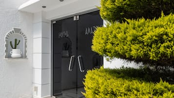The entrance of Anatol Hotel with a modern design, featuring a glass door and a clear view of the interior.