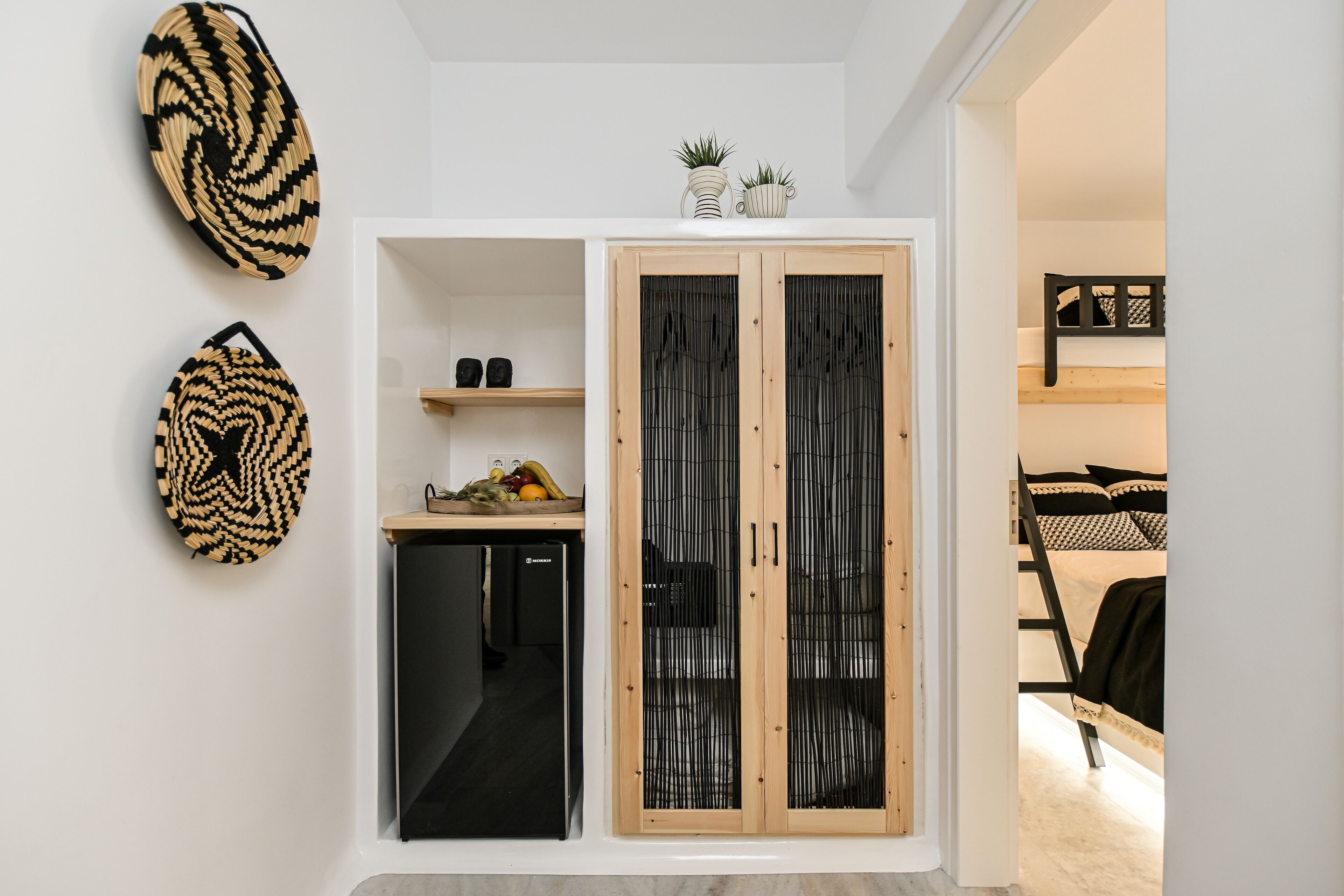 Une chambre à coucher comprenant un lit, une armoire et un petit espace bureau.