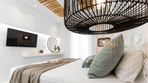 Een moderne slaapkamer met een bed, een hanglamp, een wandgemonteerde televisie en een plank met decoratieve objecten.