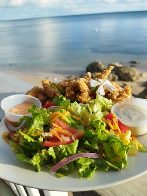 Savor a fresh salad with crisp lettuce, juicy tomatoes, and melted cheese, served with two dipping sauces.