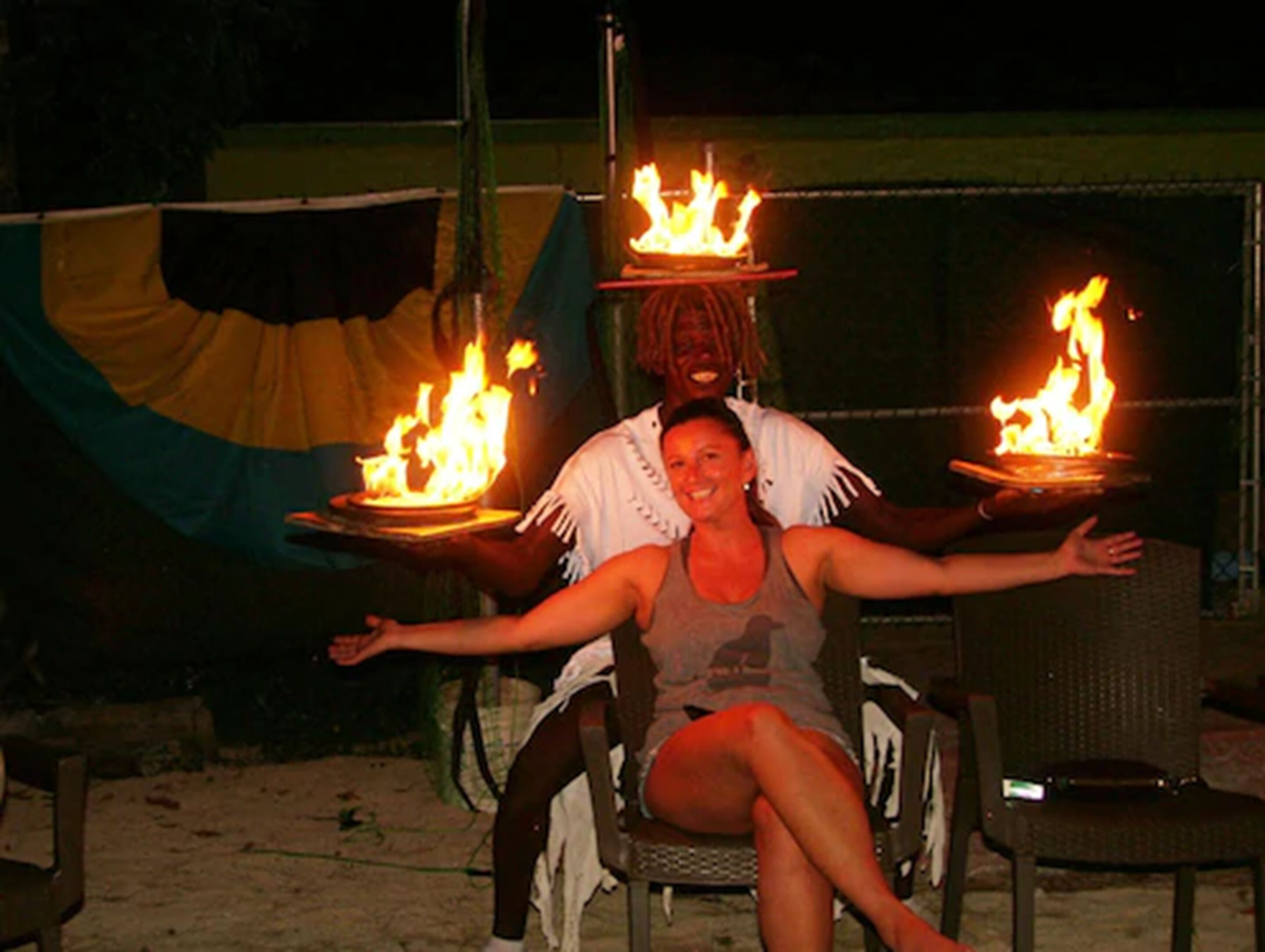 Eine Person sitzt vor Tellern mit Flammen.