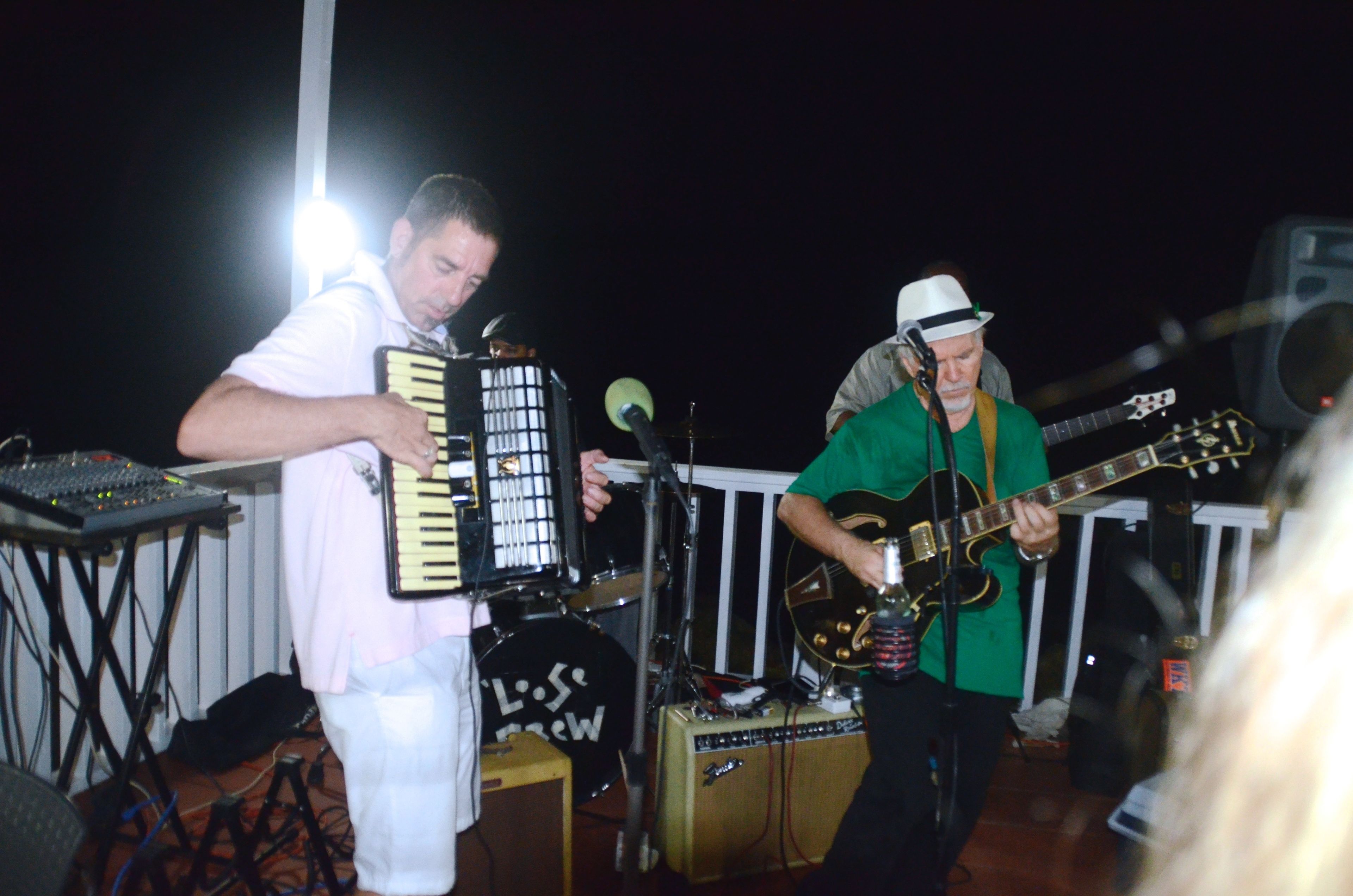 A band performing on an outdoor stage with musical instruments and equipment.