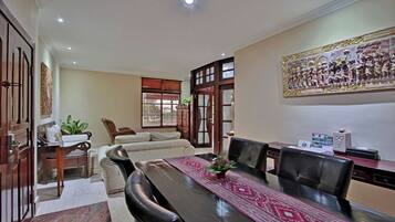 A conference room with a long table, leather chairs, a sofa, and a decorative wall piece.