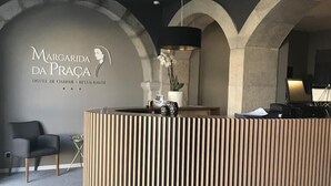 Una recepción de diseño moderno, un logotipo en la pared y una zona de estar con sillas.