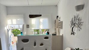 A modern kitchen with a central island, a dining area with a chair, and a view of the outdoors.