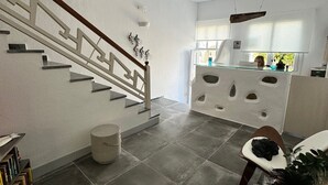 A modern interior with a staircase, a kitchen area, and a seating area.