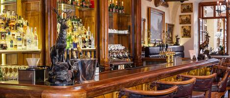 Un bar con decoración de madera, sillas de cuero y una variedad de botellas y vasos.