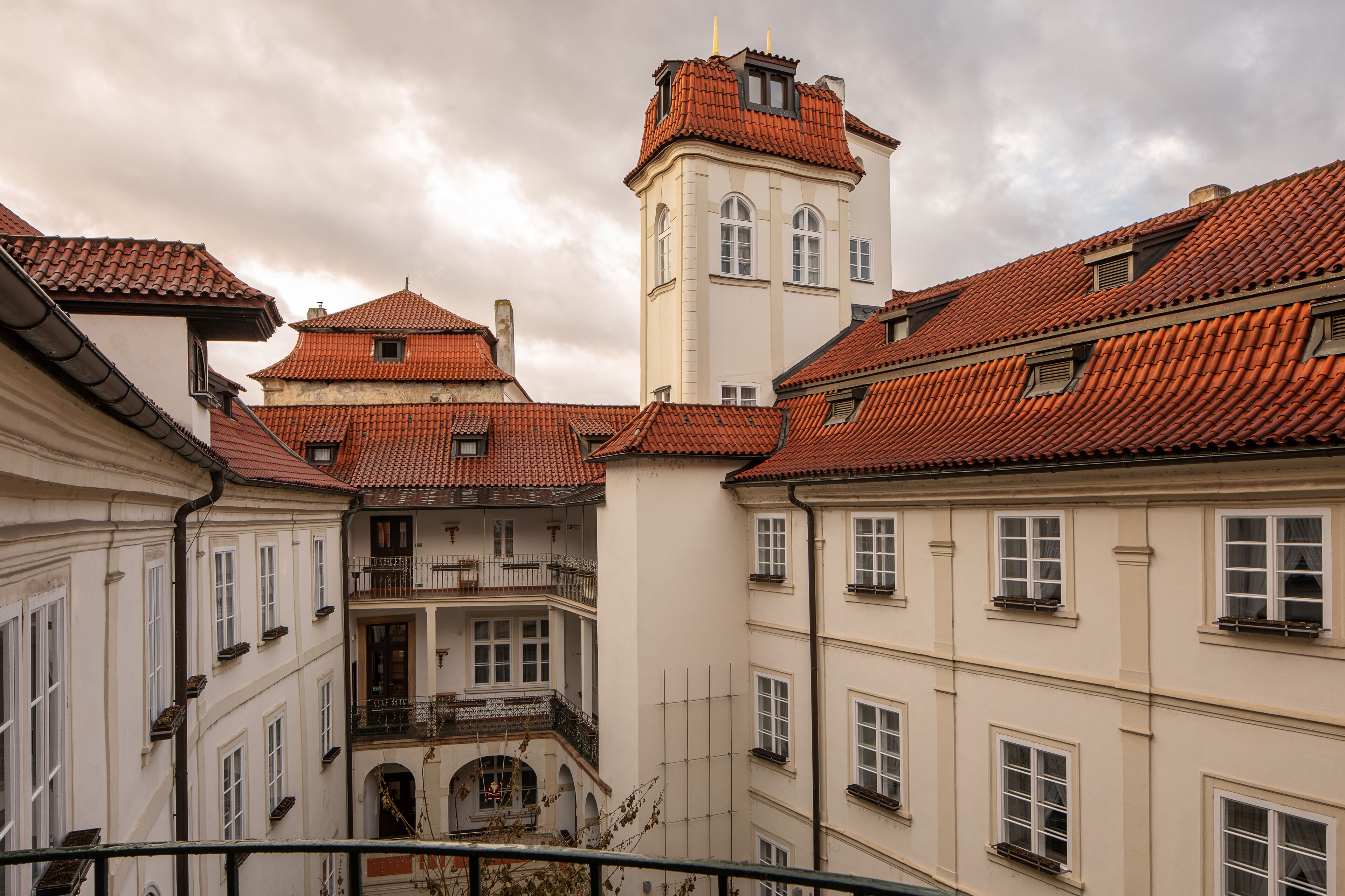 A historic building with red-tiled roofs and a central tower.
