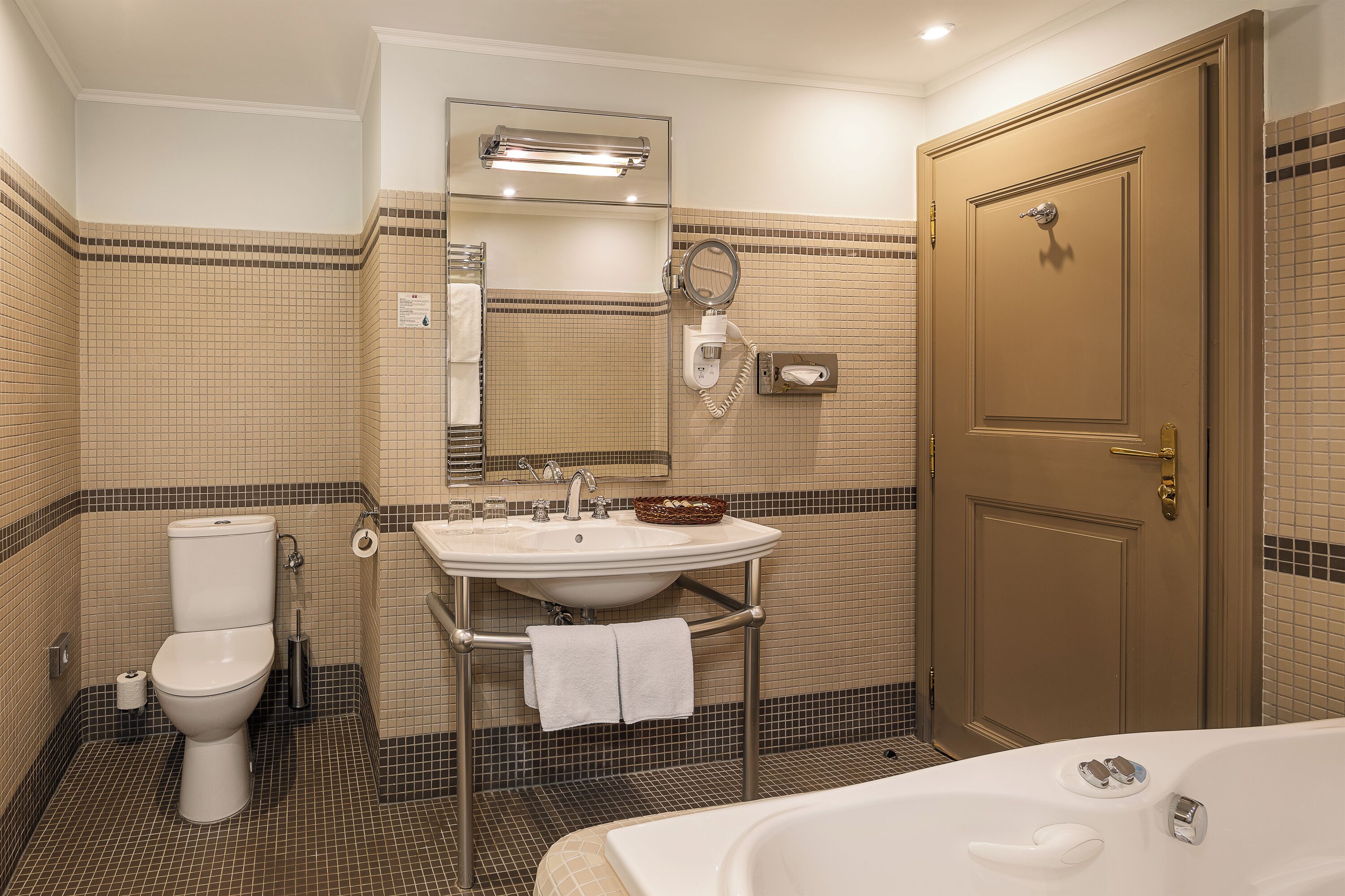 Un baño con inodoro, lavamanos y bañera.
