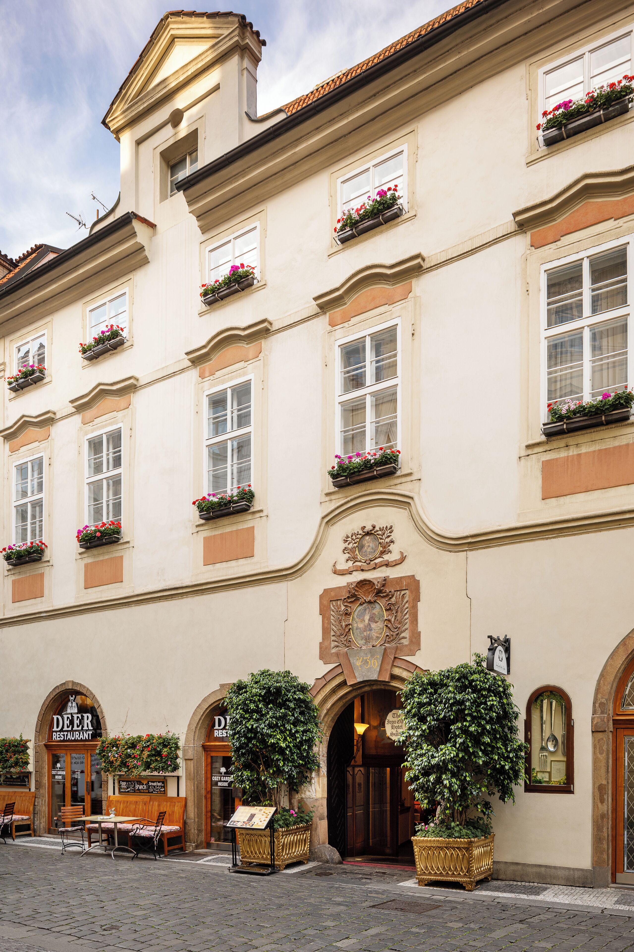Un edificio histórico con múltiples ventanas, algunas con jardineras, y un letrero que dice 'Deer Restaurant' en la entrada.