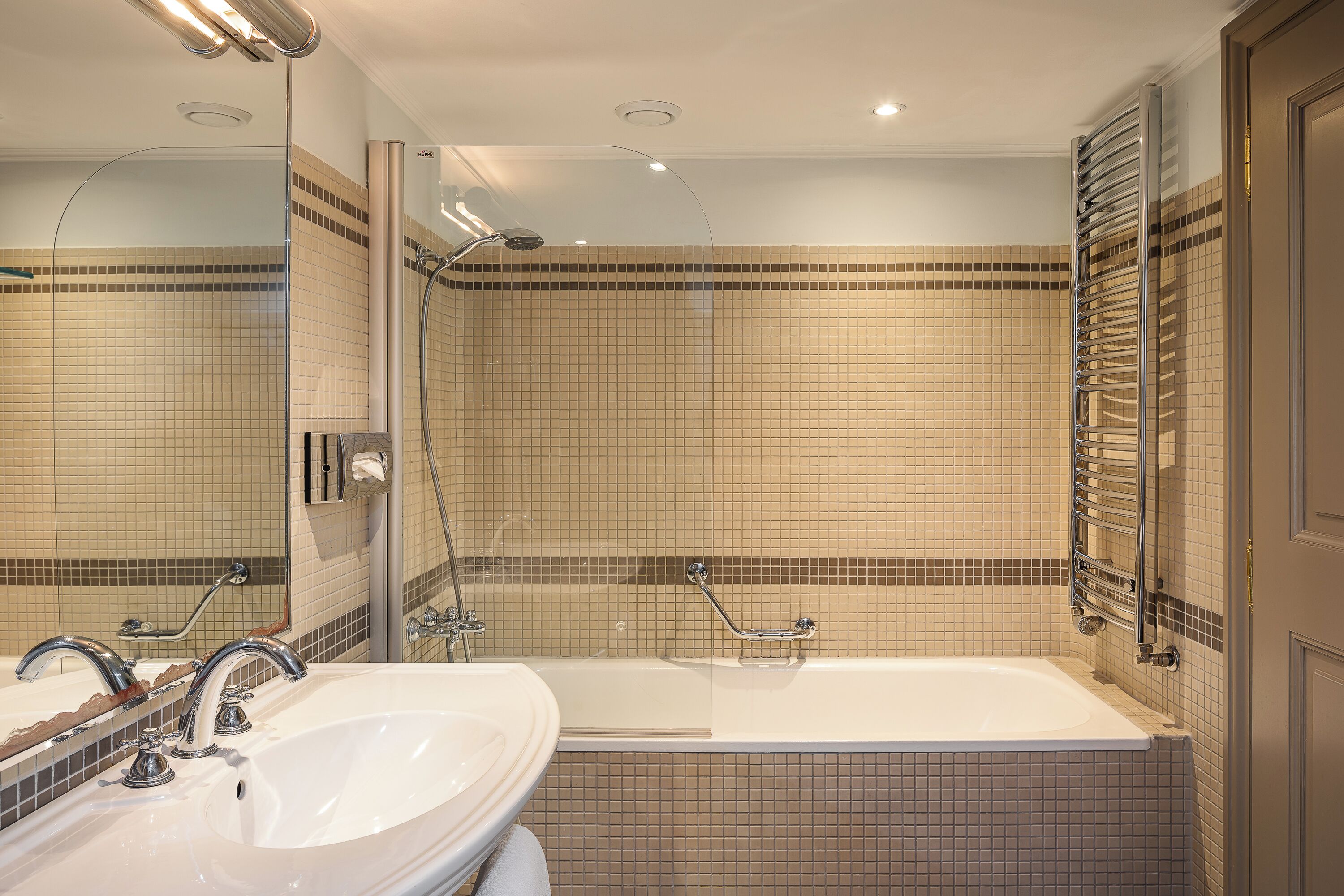 A bathroom with a large bathtub, two sinks, and a shower.