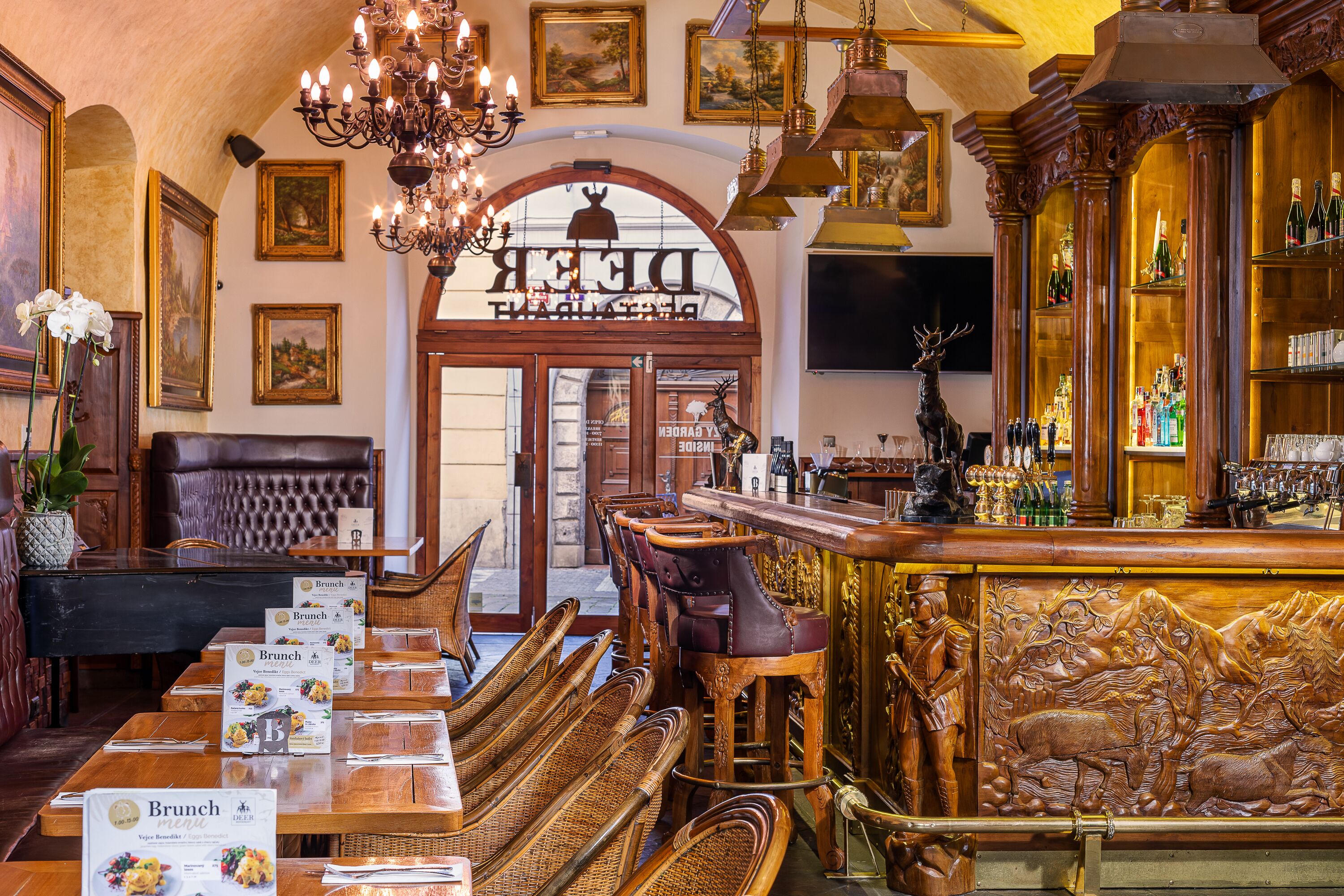 Ein Restaurant mit Holztischen, einer Bar und einem Kronleuchter.