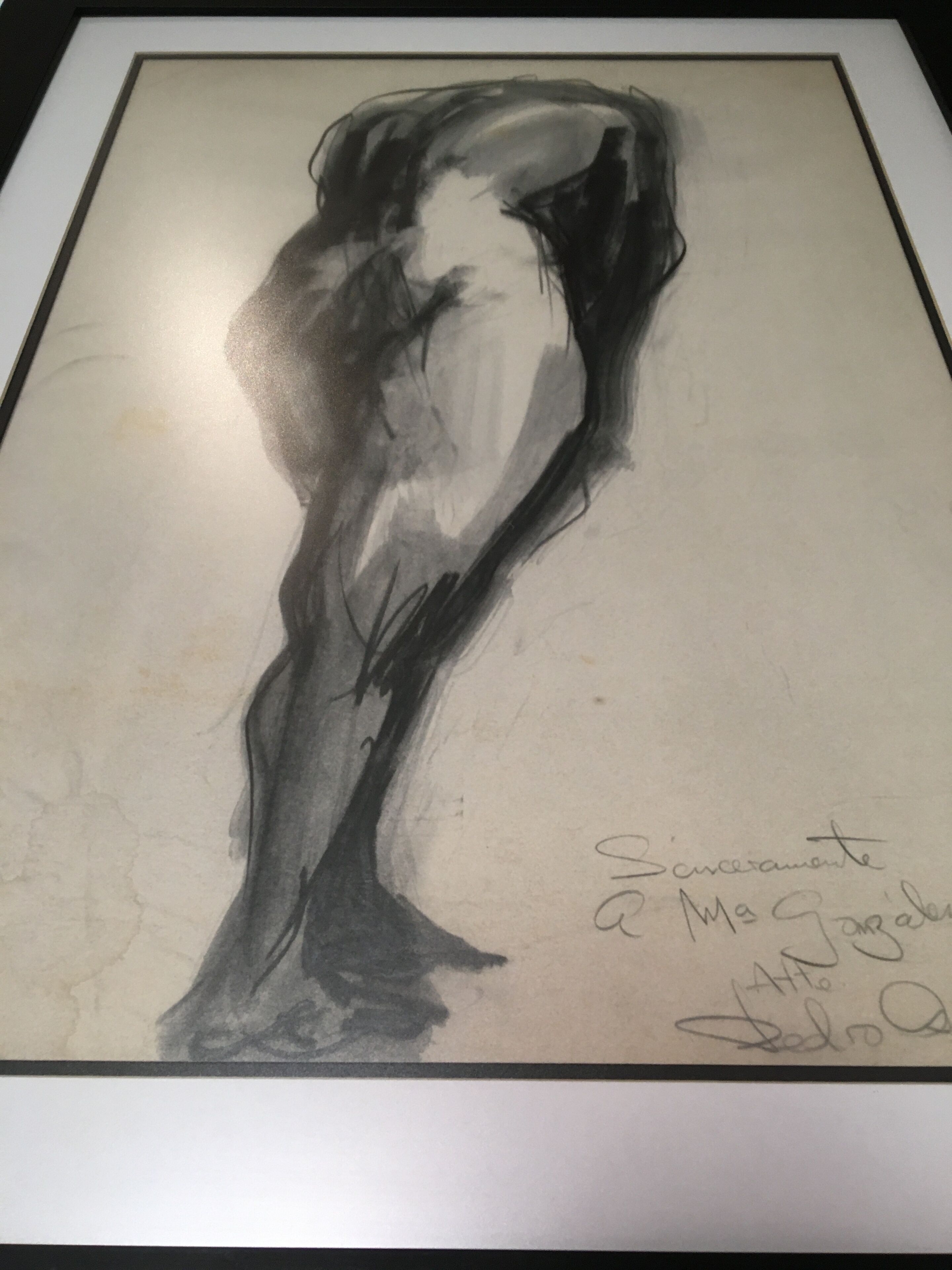 Una obra de arte enmarcadas que muestra una figura y una firma.