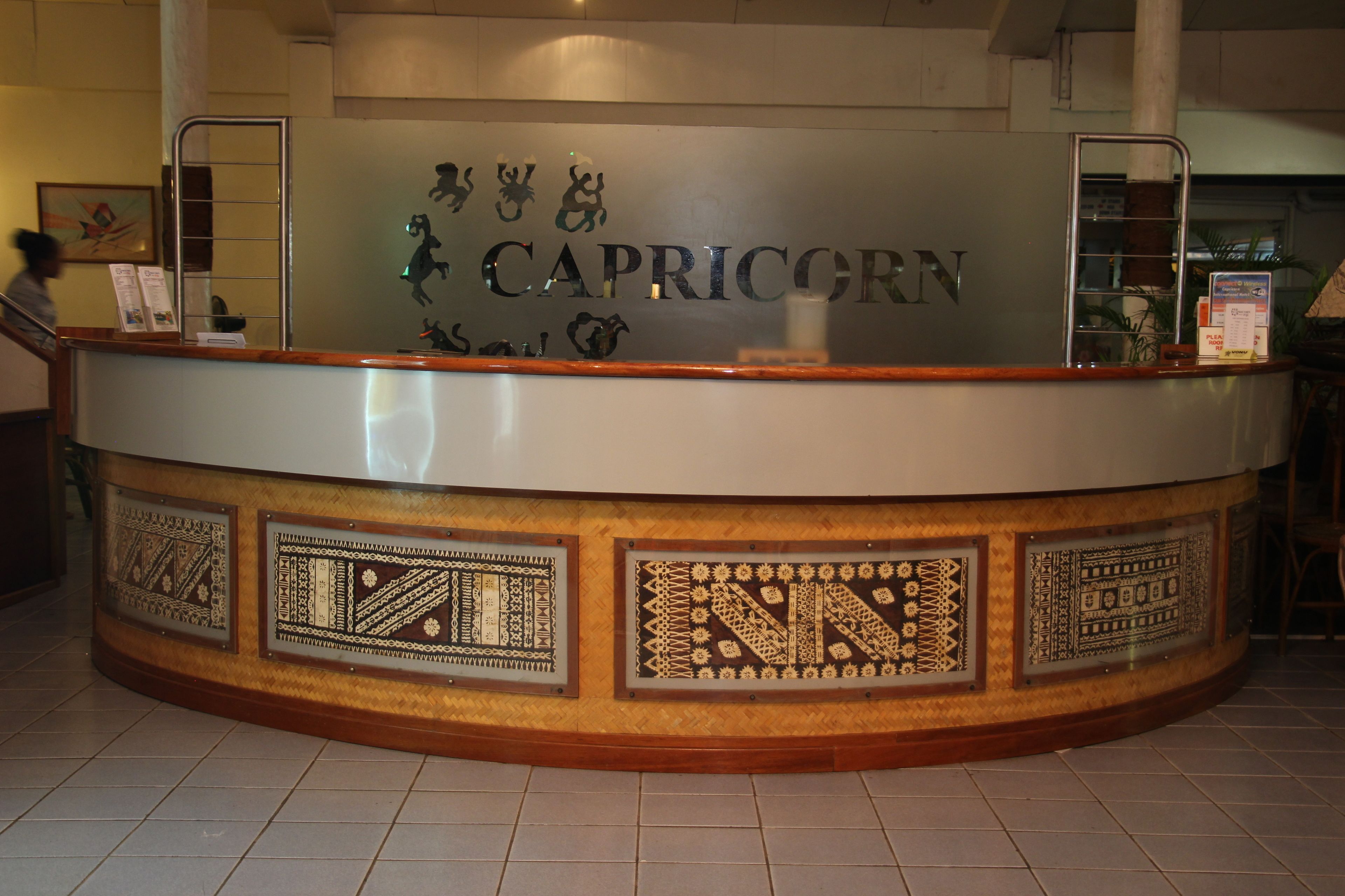 A reception desk with a sign reading "CAPRICORN" and decorative panels.