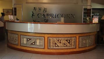A reception desk with a sign reading "CAPRICORN" and decorative panels.