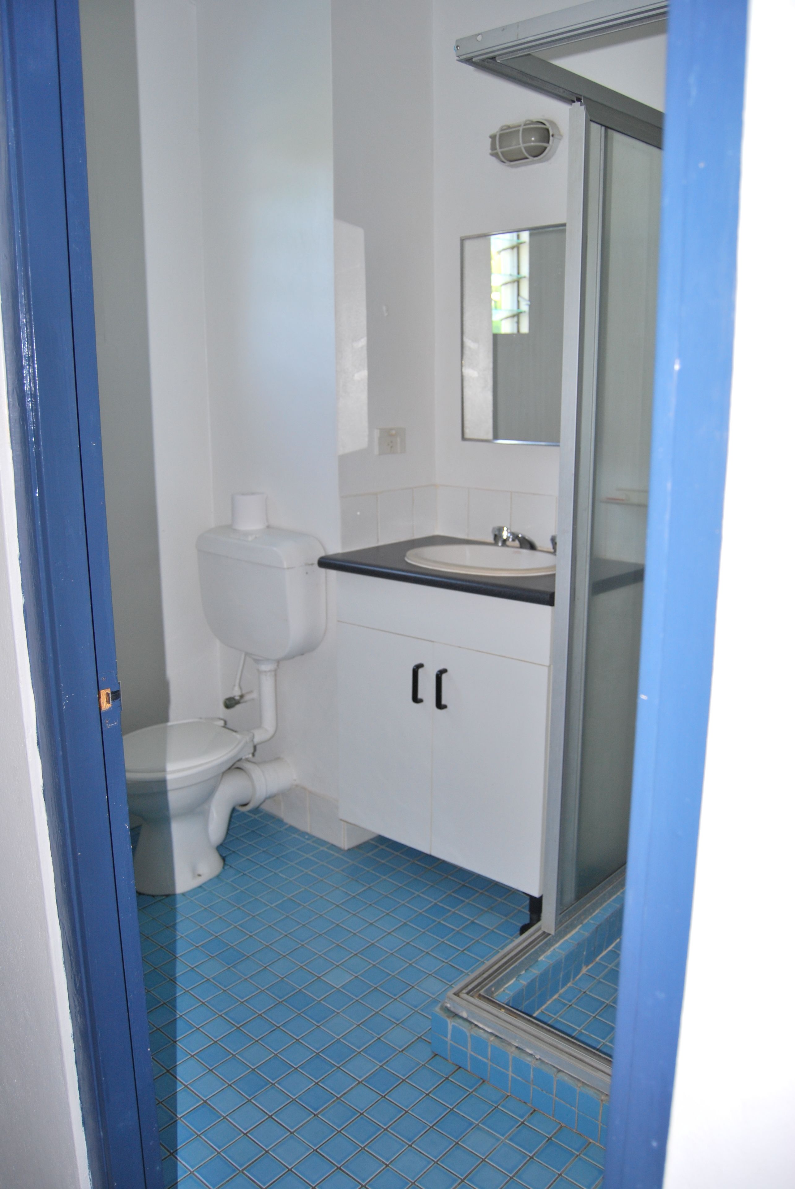 A bathroom with a toilet, sink, and shower.