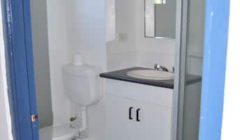 A bathroom with a toilet, sink, and shower.