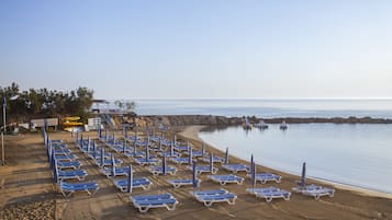 Am Strand, weißer Sandstrand, Liegestühle, Sonnenschirme