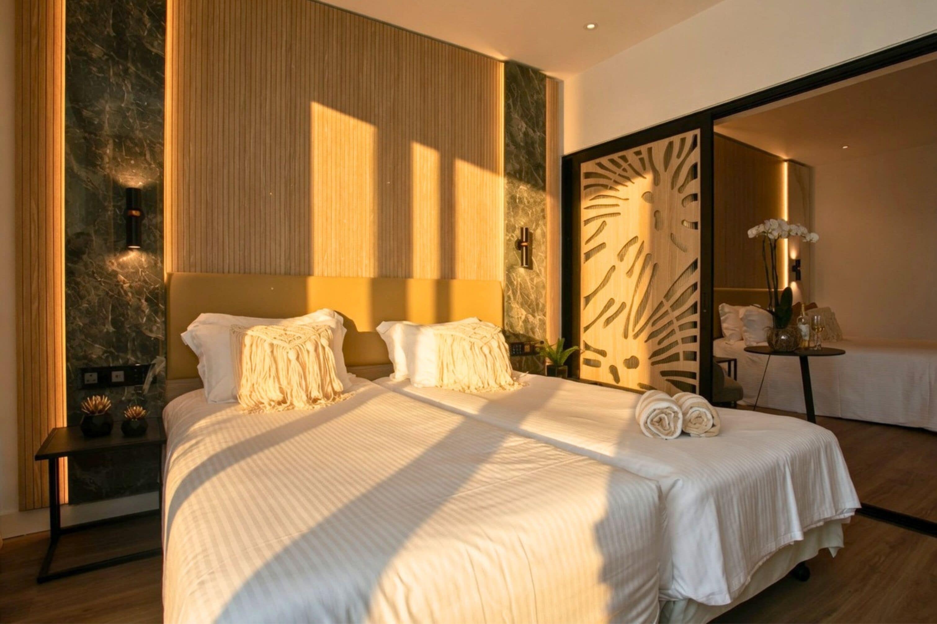 Een slaapkamer met een groot bed, nachtkastje en een spiegel.