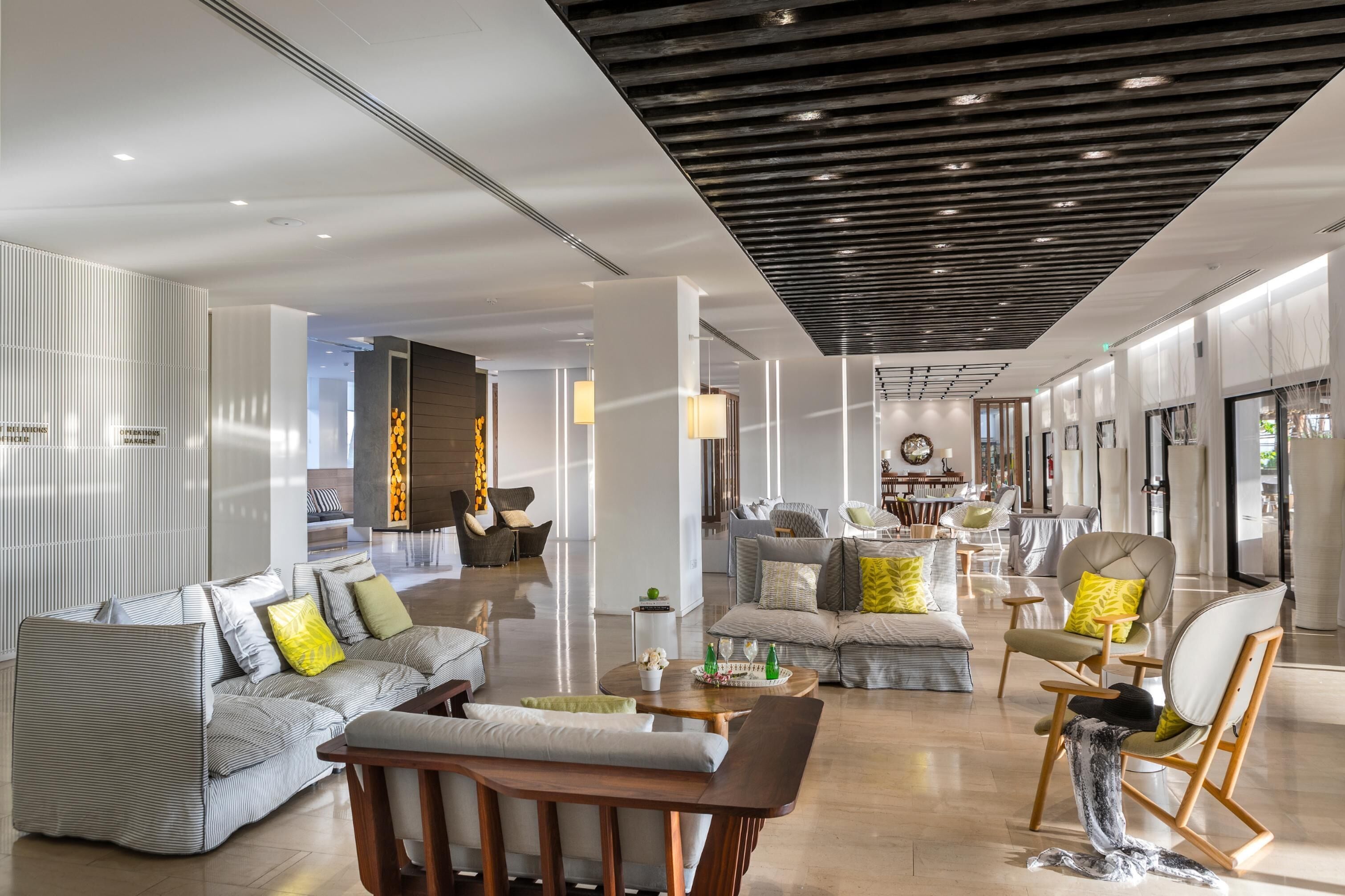 Un hall d’hôtel spacieux, doté d’un mobilier moderne, notamment des canapés, des fauteuils et une table basse.