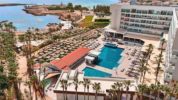 Een binnenzwembad, 2 buitenzwembaden en parasols bij het zwembad