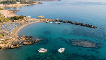 PĂ„ stranden, vit sandstrand, solstolar och parasoller