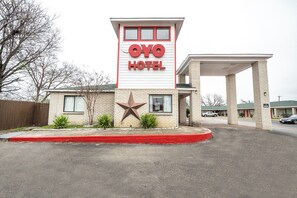 A hotel with a prominent 'OYO Hotel' sign, a large star decoration, and a covered parking area. - OYO Hotel San Antonio Near At&t Center (San Antonio)