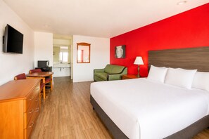 A hotel room with a bed, a desk, a chair, a TV, and a bathroom visible in the background. - OYO Hotel San Antonio Near At&t Center (San Antonio)