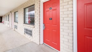 A row of brick buildings with red doors, numbered 124, and a covered walkway.