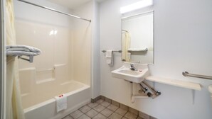 Un baño con bañera, lavabo, espejo y cortina de ducha.