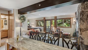 Un salón espacioso con una pared de acento de piedra, una mesa de comedor con sillas y una zona de estar acogedora con un sofá y sillones.