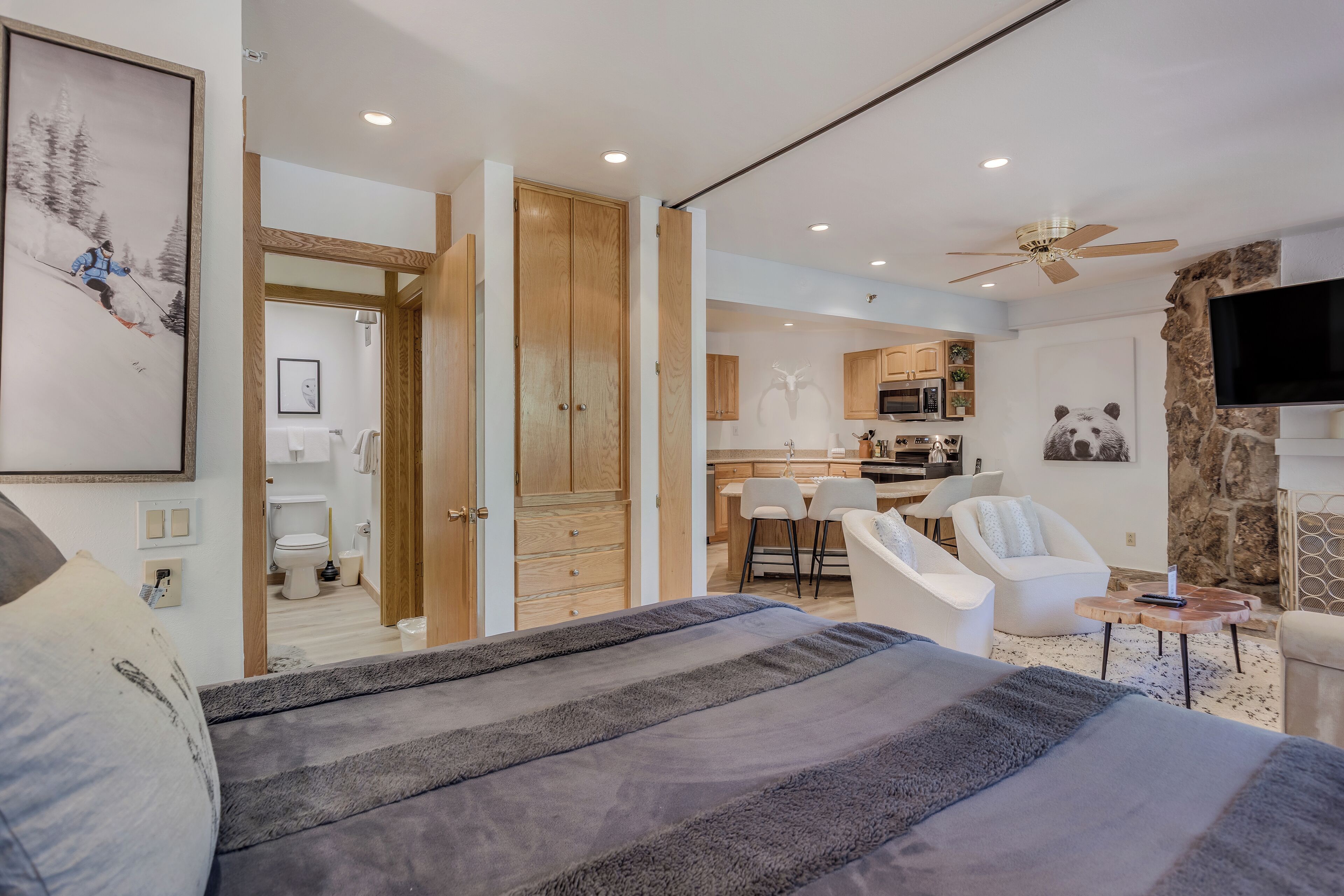 Quarto moderno com cama grande, área de refeições e cozinha.
