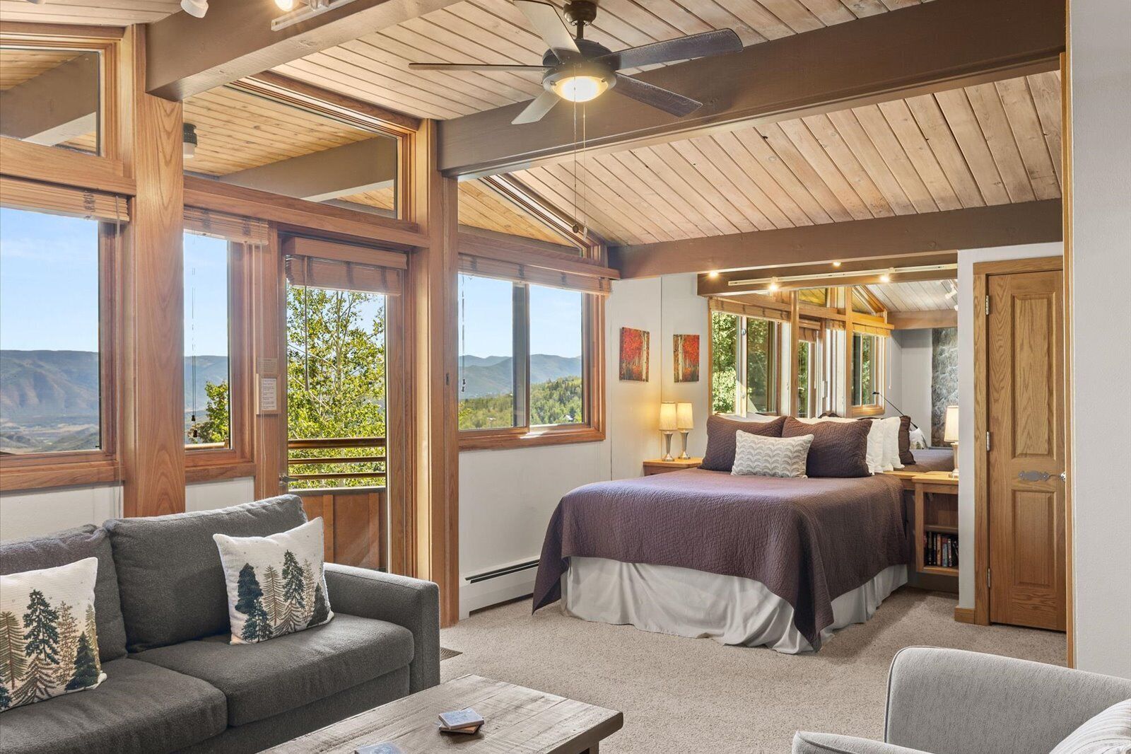 Un dormitorio con una cama grande, un sofá y vistas al exterior.