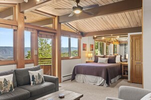 Un dormitorio con una cama grande, un sofá y vistas al exterior.