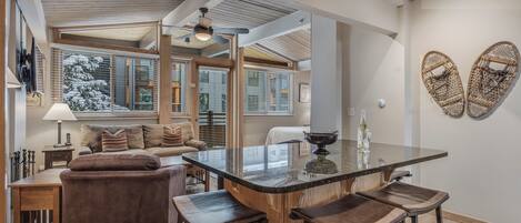 A spacious kitchen with a central island, bar stools, and a ceiling fan.