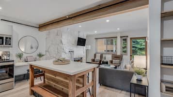Una cocina moderna con pared de piedra, vigas de madera y un comedor con chimenea.