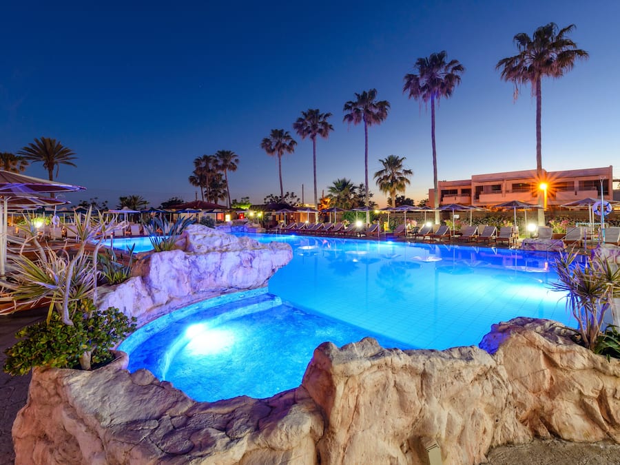 Una piscina cubierta, una piscina al aire libre, tumbonas