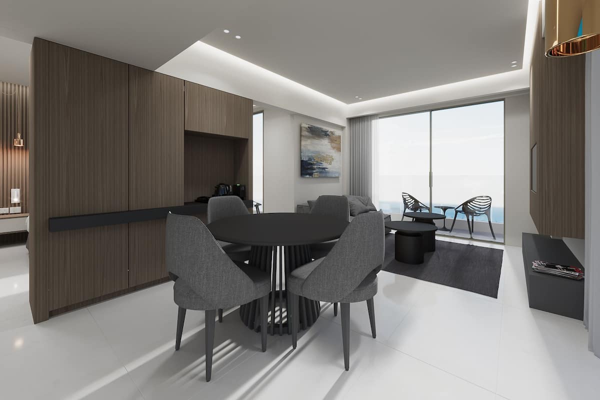 Un interior moderno con comedor, cocina y un balcón con sillas.