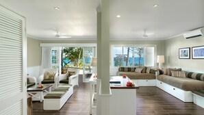 A spacious living area with a large window, white furniture, and a view of the outdoors. - Malolo Island Resort (Malolo Island)