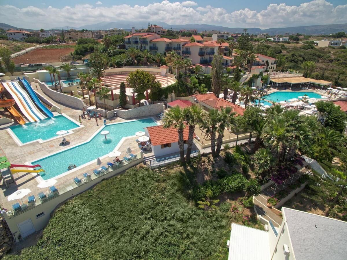 Um resort com várias piscinas, um tobogã e vista para a paisagem ao redor.