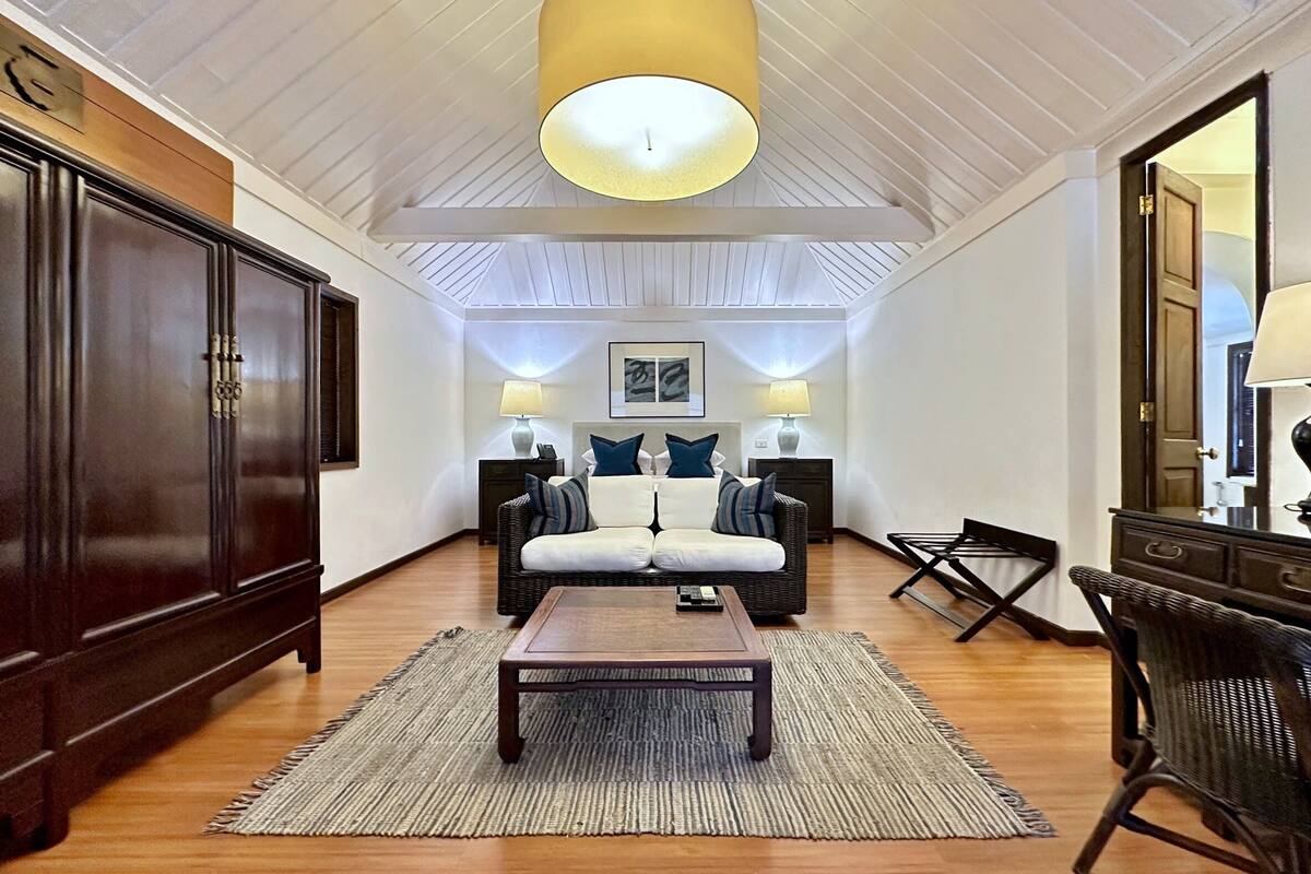 A room with a sofa, a table, a lamp, and a cabinet.
