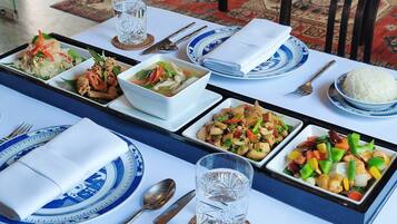 Una mesa de comedor dispuesta con diferentes platos, cubiertos y vasos.